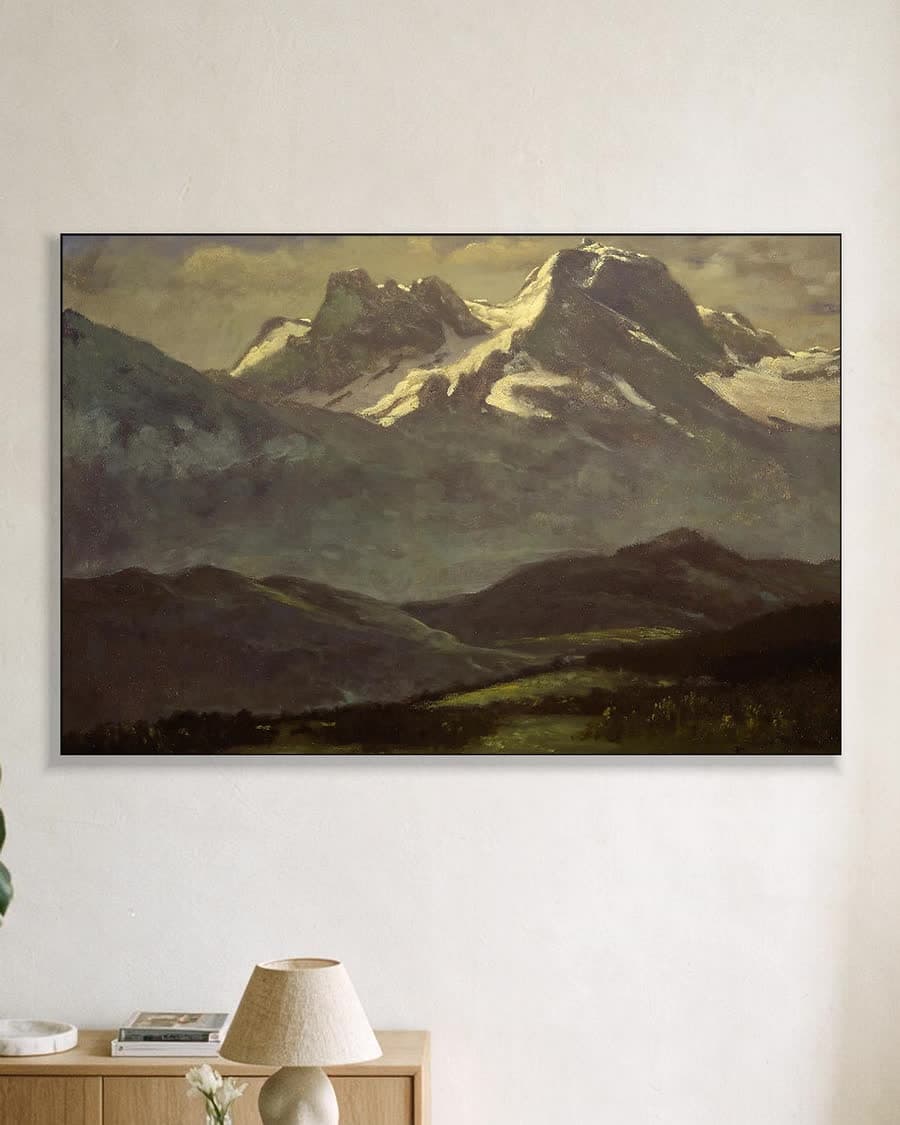 Besneeuwde bergtoppen in de avondzon in een aluminium frame aan dezelfde muur