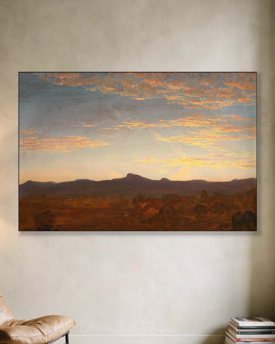 Avondgloed boven de bergen in een aluminium frame aan dezelfde muur