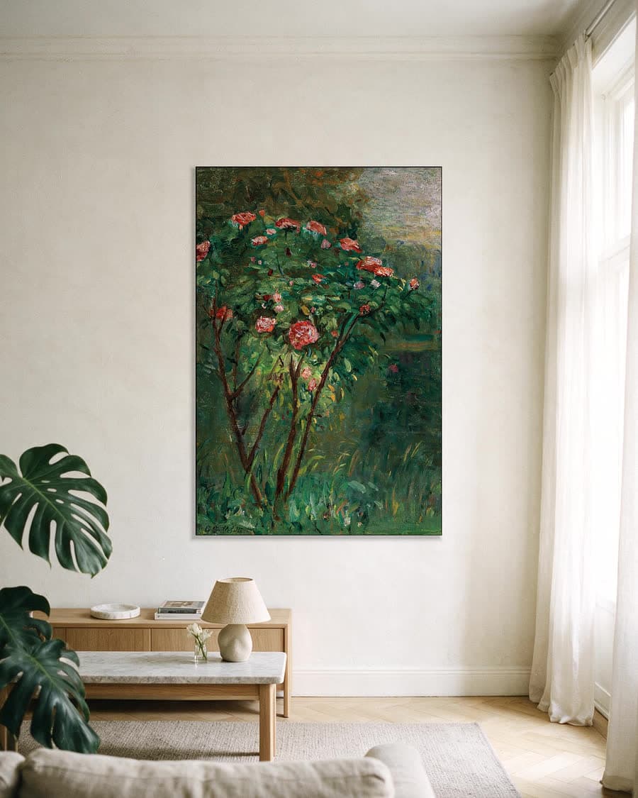 De bloeiende rozenstruik in een aluminium frame aan dezelfde muur