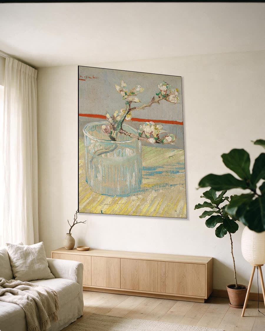 Tak bloeiende amandel in een glas in een aluminium frame aan dezelfde muur