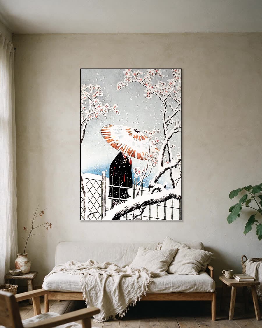 Bloesemboom in de sneeuw met paraplu in een aluminium frame aan dezelfde muur
