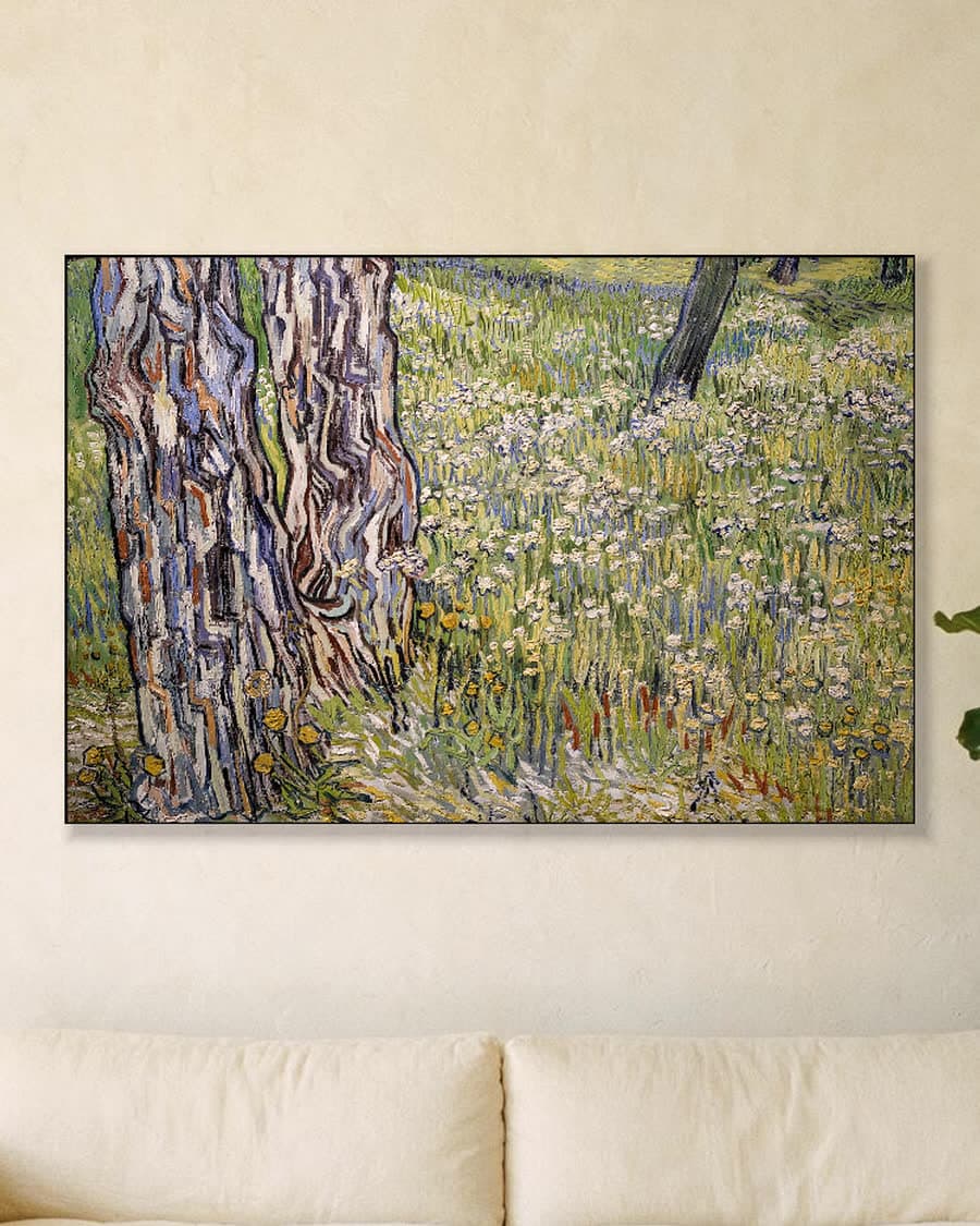 Bloeiende weide met bomen en paardenbloemen in een aluminium frame aan dezelfde muur