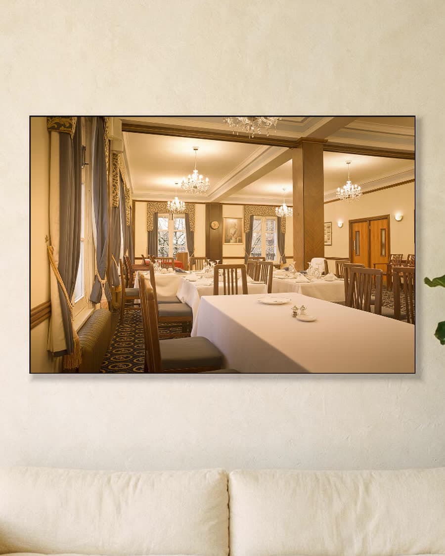 In de eetkamer in een aluminium frame aan dezelfde muur