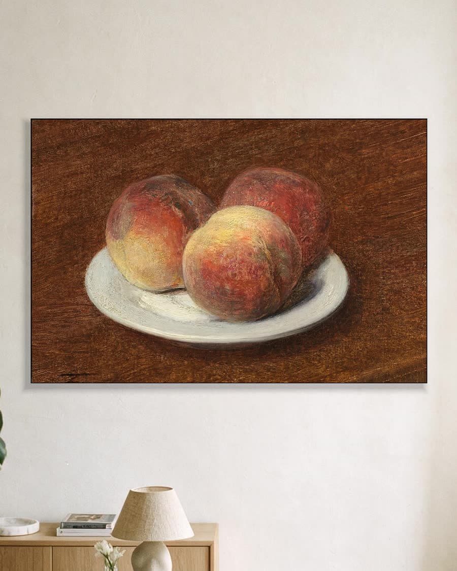 Drie perziken op een bord in een aluminium frame aan dezelfde muur