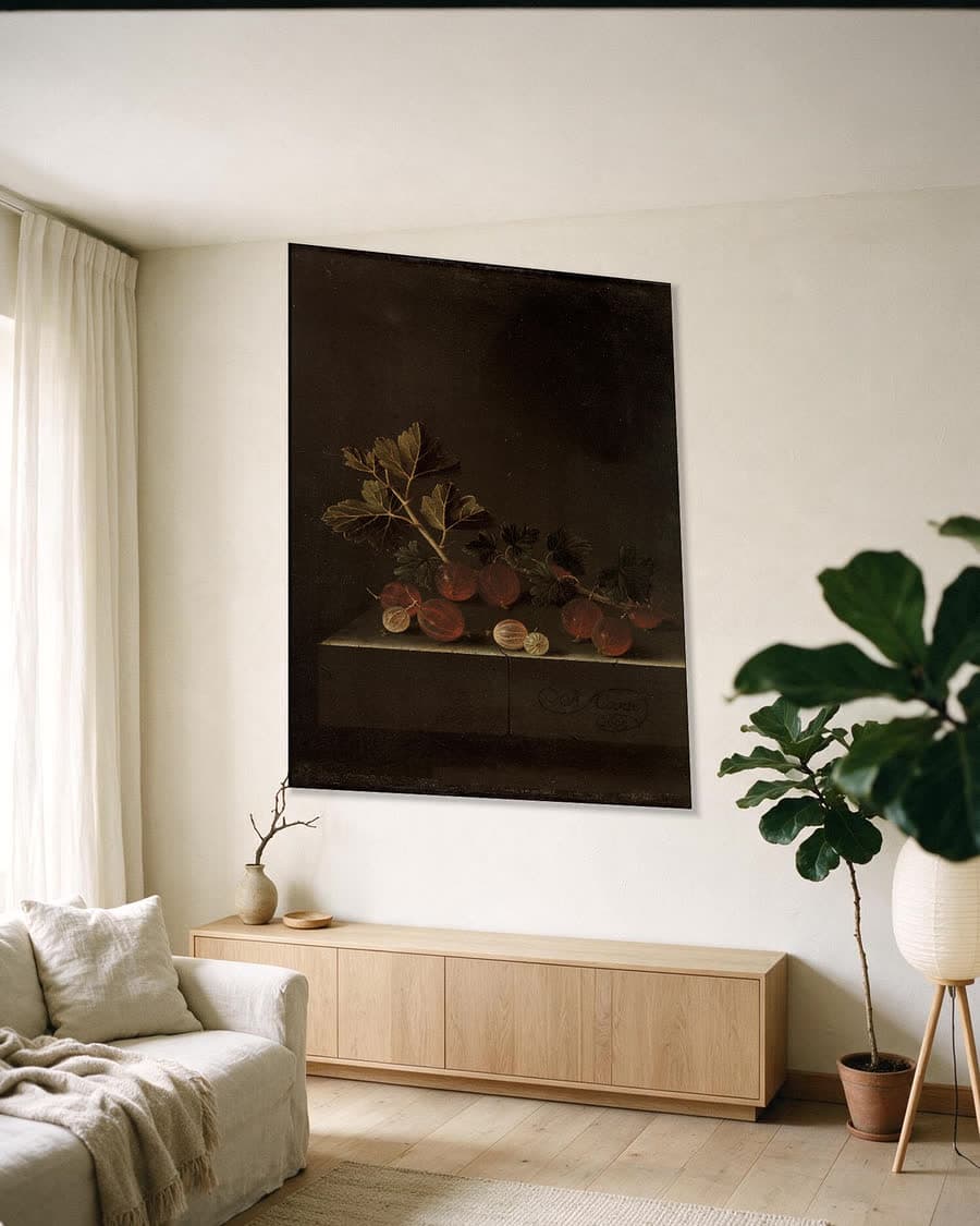 Een takje kruisbessen op een stenen plint in een aluminium frame aan dezelfde muur