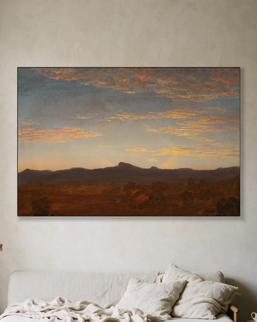 Avondgloed boven de bergen in een aluminium frame aan dezelfde muur