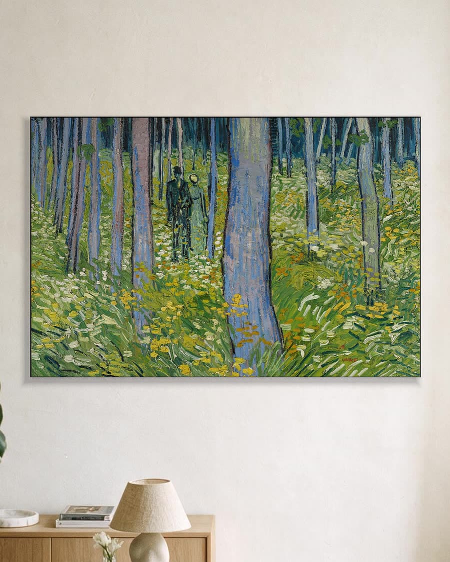 Kreupelhout met twee figuren in een aluminium frame aan dezelfde muur