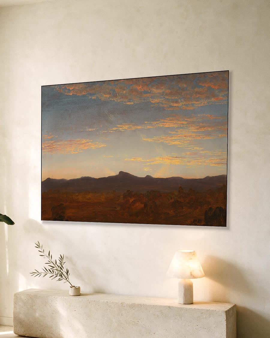 Avondgloed boven de bergen in een aluminium frame aan dezelfde muur