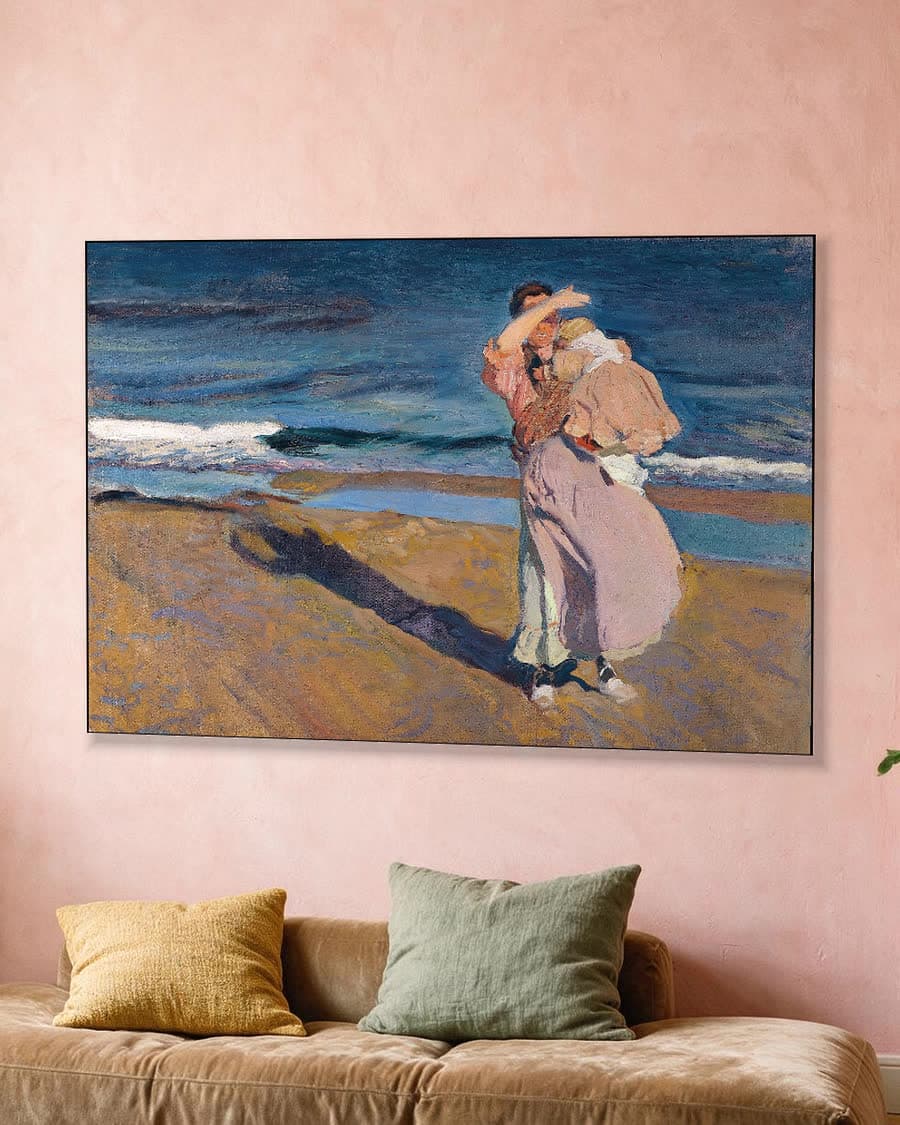 Vissersvrouw met haar kind in een aluminium frame aan dezelfde muur