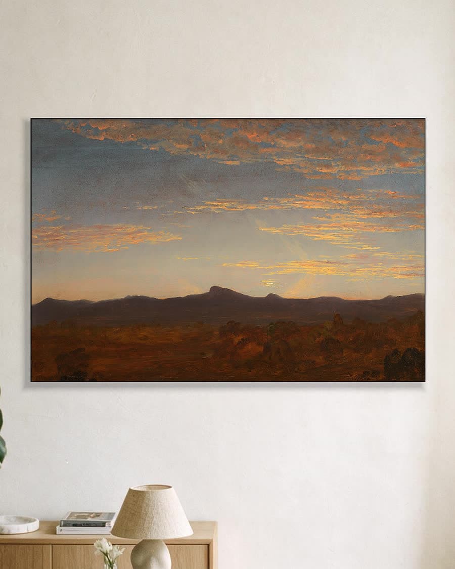 Avondgloed boven de bergen in een aluminium frame aan dezelfde muur