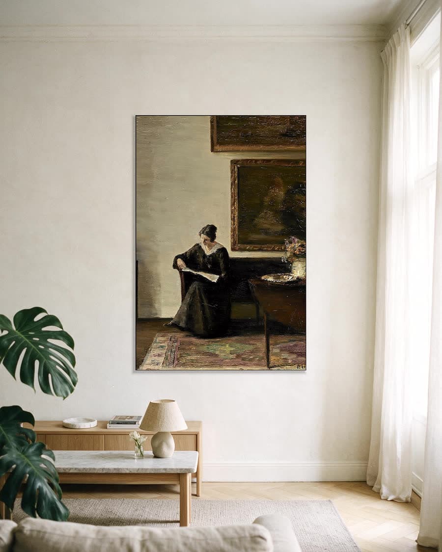 Interieur met lezende vrouw bij het venster in een aluminium frame aan dezelfde muur