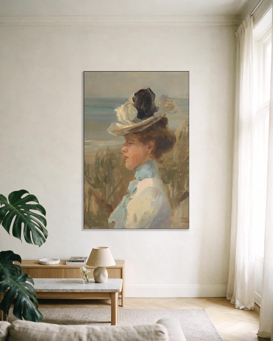 Jonge vrouw, kijkend naar de zee in een aluminium frame aan dezelfde muur