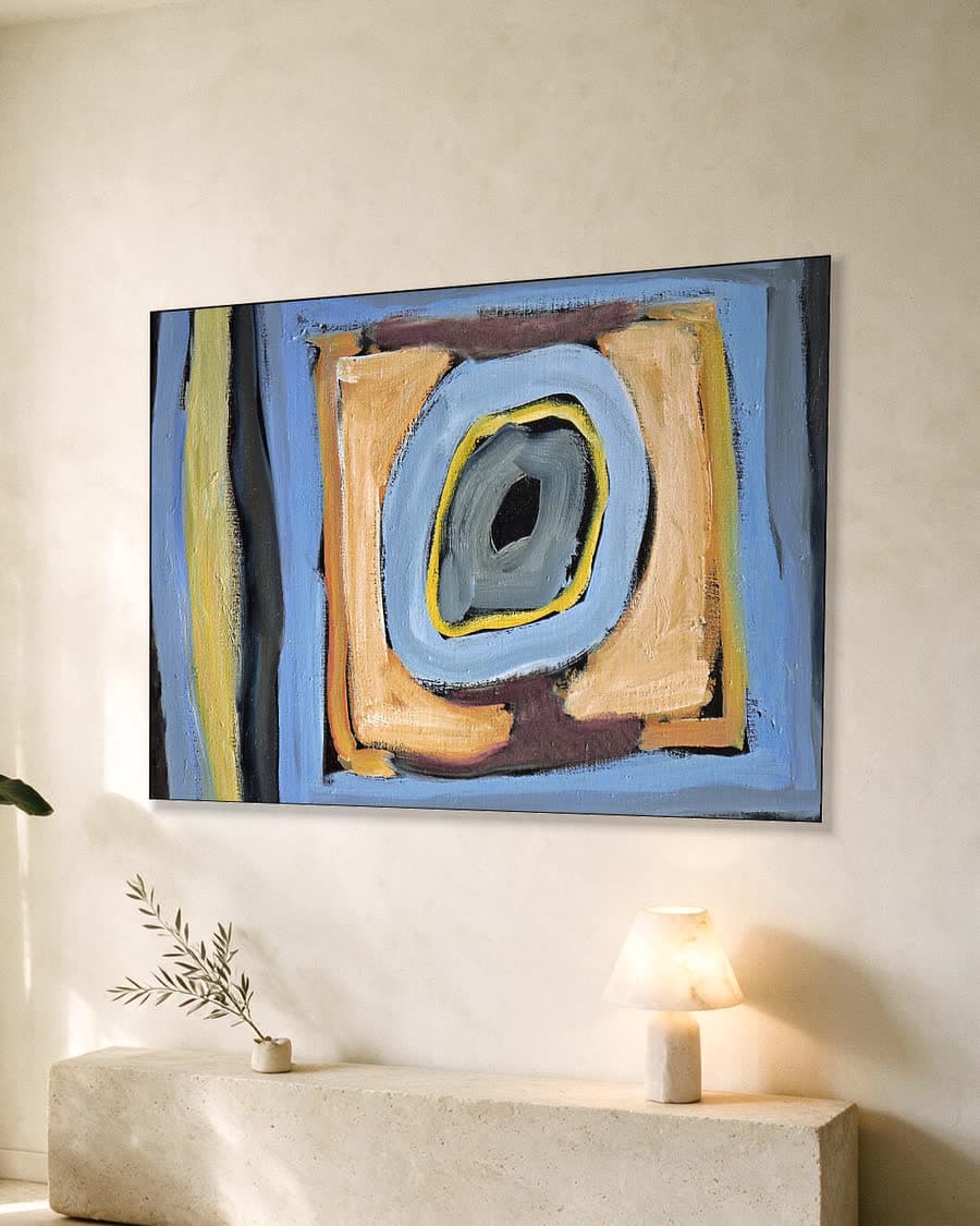 Abstracte vormen in blauw en oker in een aluminium frame aan dezelfde muur
