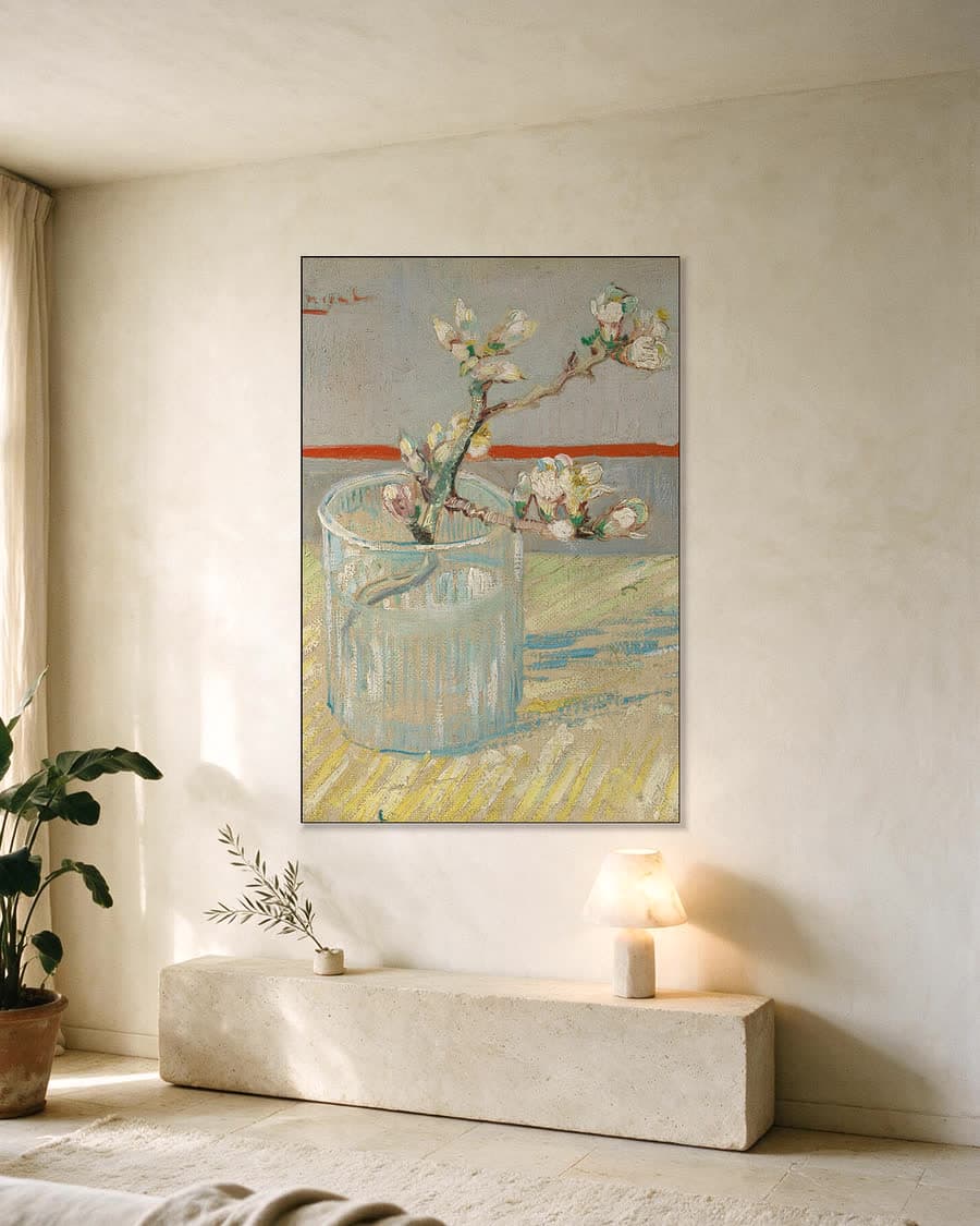 Tak bloeiende amandel in een glas in een aluminium frame aan dezelfde muur
