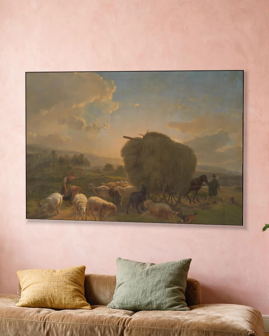 Landschap met schapen en een hooiwagen in een aluminium frame aan dezelfde muur