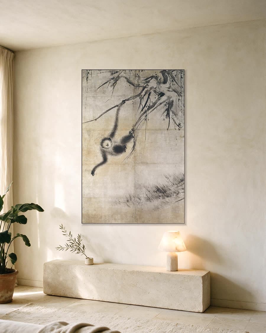 Aap hangend aan een tak in een aluminium frame aan dezelfde muur