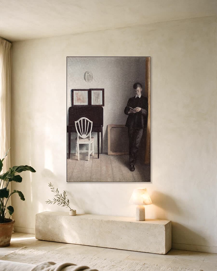 Interieur met een lezende jonge man in een aluminium frame aan dezelfde muur
