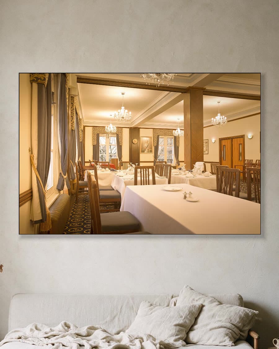 In de eetkamer in een aluminium frame aan dezelfde muur
