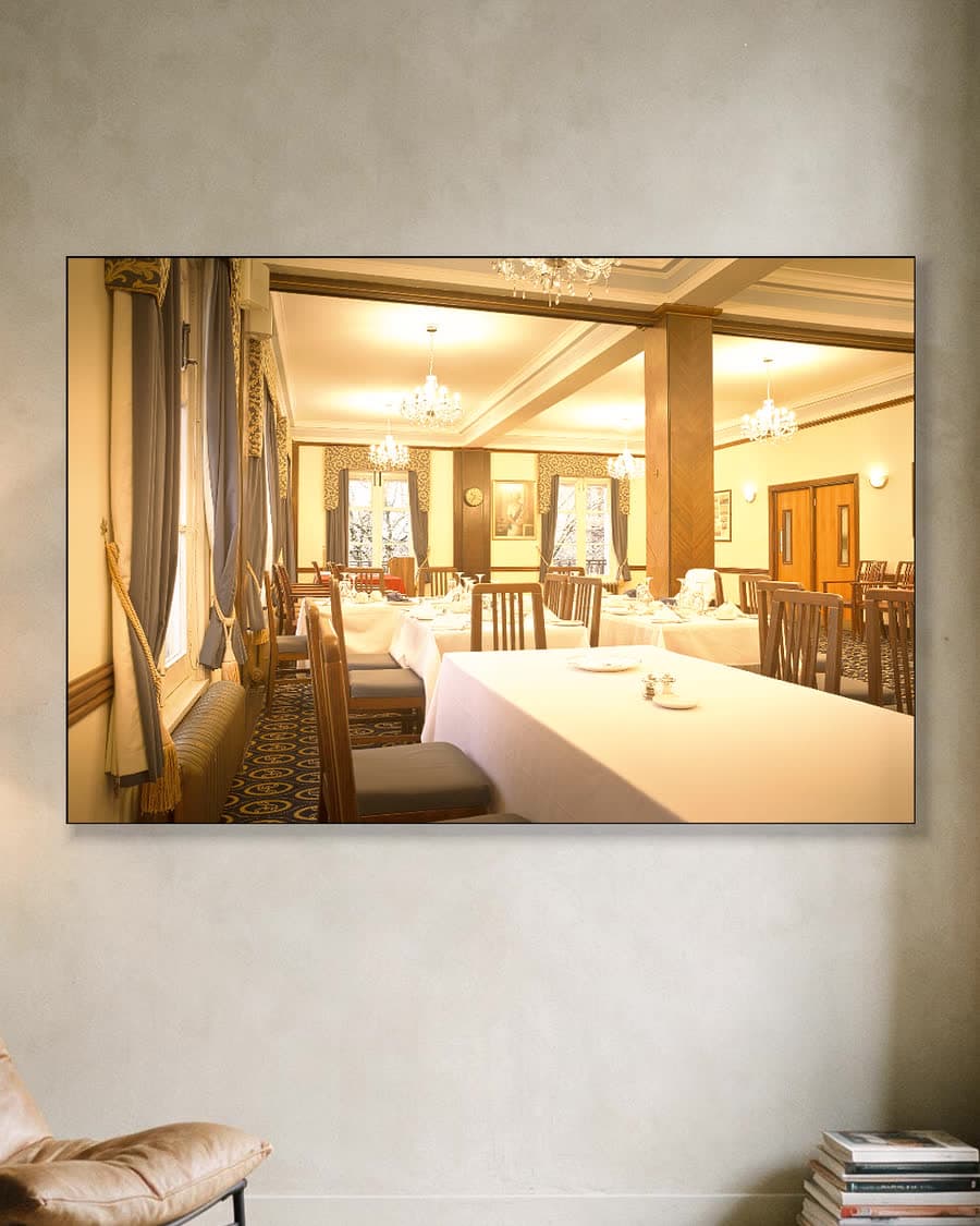 In de eetkamer in een aluminium frame aan dezelfde muur