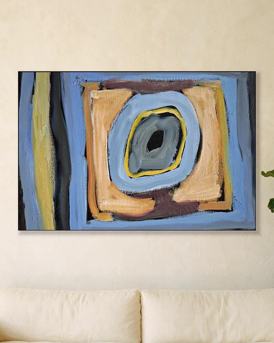 Abstracte vormen in blauw en oker in een aluminium frame aan dezelfde muur