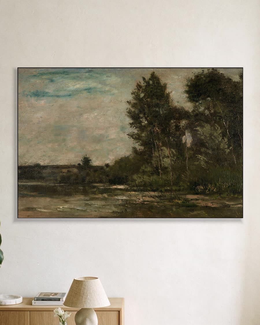 Rustig landschap met bomen en water in een aluminium frame aan dezelfde muur