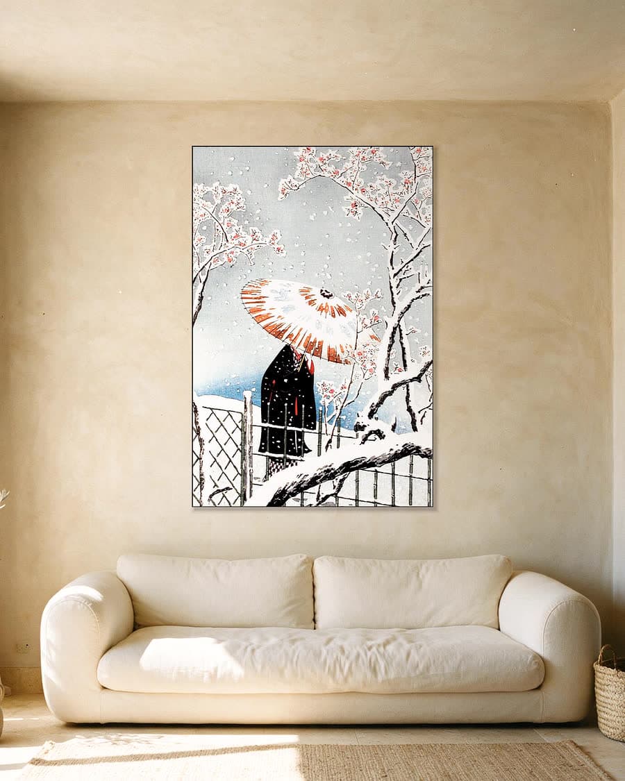 Bloesemboom in de sneeuw met paraplu in een aluminium frame aan dezelfde muur