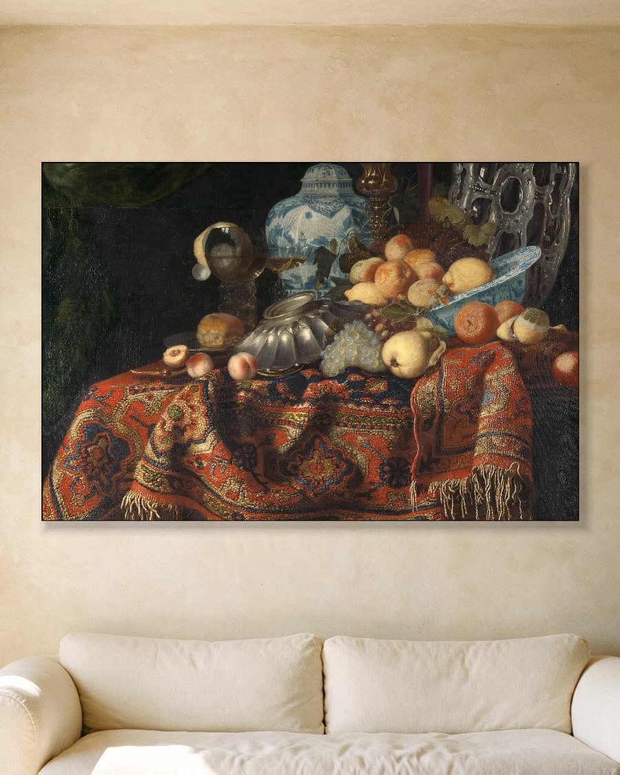 Stilleven met fruit, borden en schalen op een Turks tapijt in een aluminium frame aan dezelfde muur