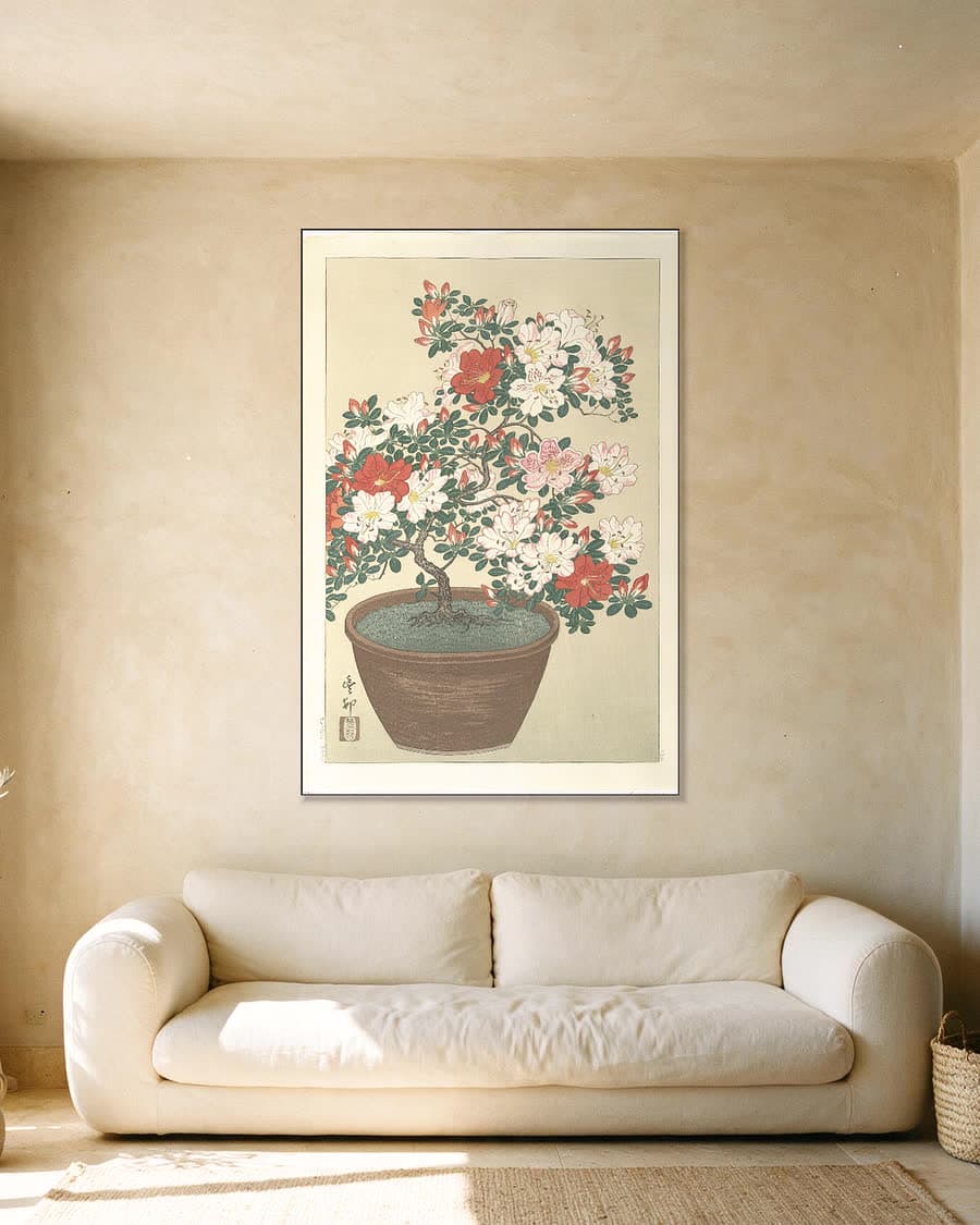 Bloeiende azalea in bruine pot in een aluminium frame aan dezelfde muur