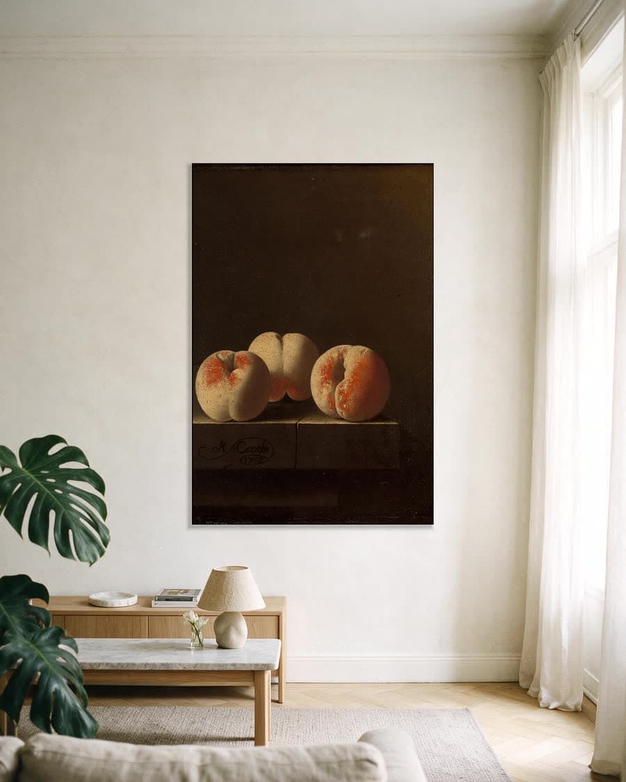 Drie perziken op een stenen plint in een aluminium frame aan dezelfde muur