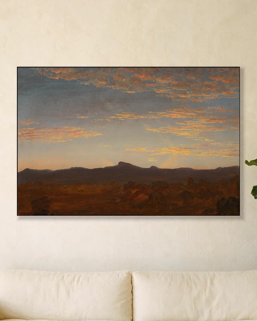 Avondgloed boven de bergen in een aluminium frame aan dezelfde muur