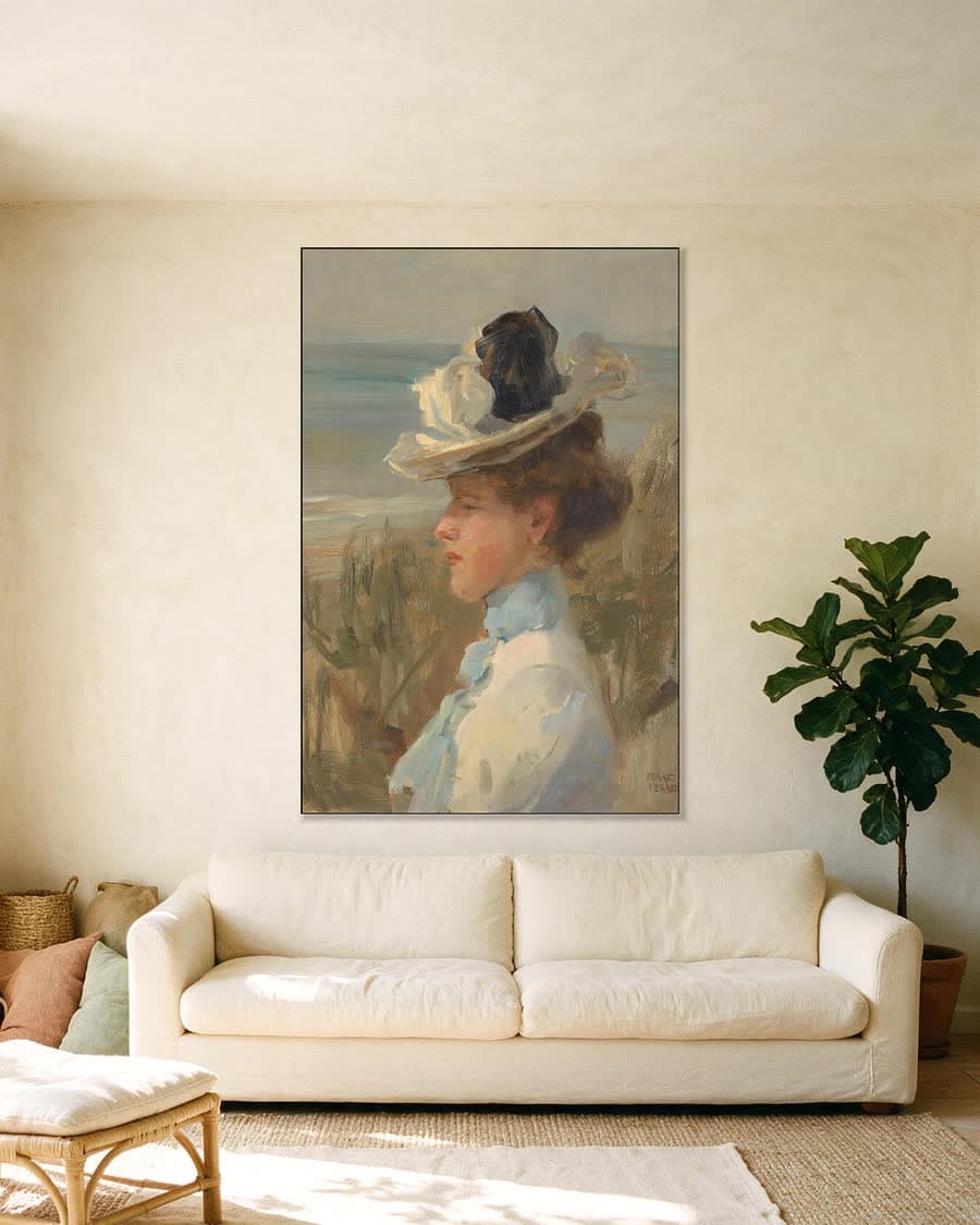 Jonge vrouw, kijkend naar de zee in een aluminium frame aan dezelfde muur