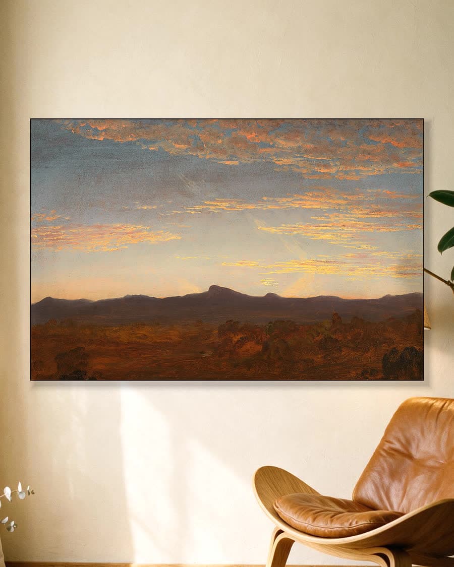 Avondgloed boven de bergen in een aluminium frame aan dezelfde muur