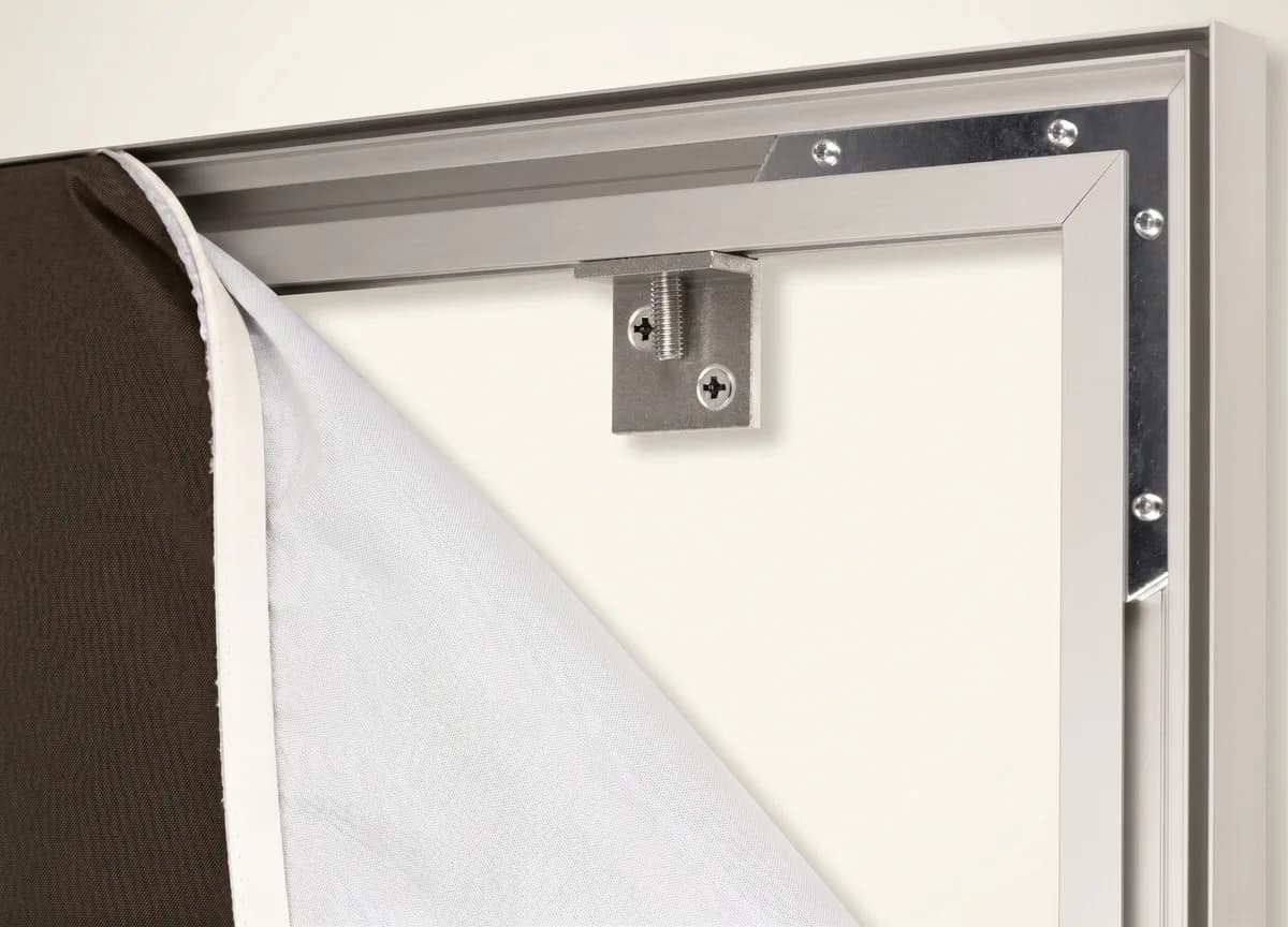 De bovenhoek van het frame van achteren, met het doek opzijgevouwen: de muurbeugel zit vast in het aluminium profiel