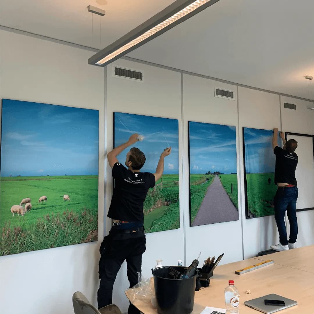 Twee vakmensen hangen panoramadoeken op in een vergaderruimte