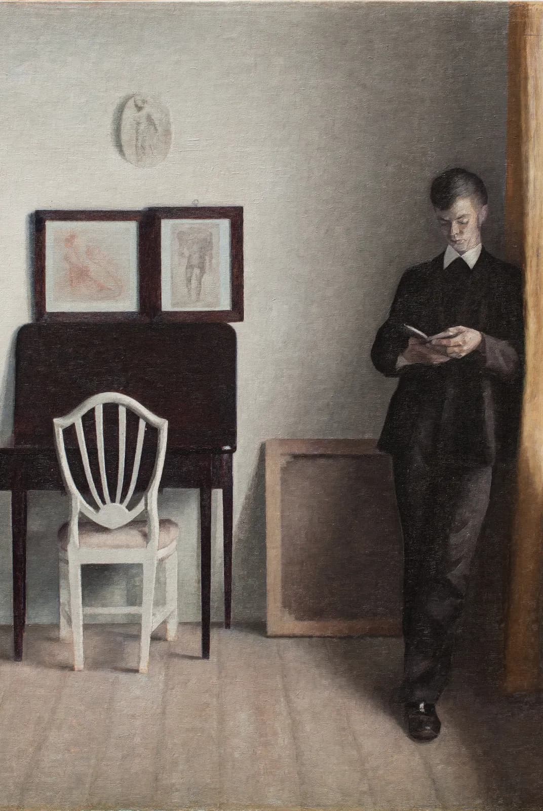 Interieur met een lezende jonge man – Vilhelm Hammershøi