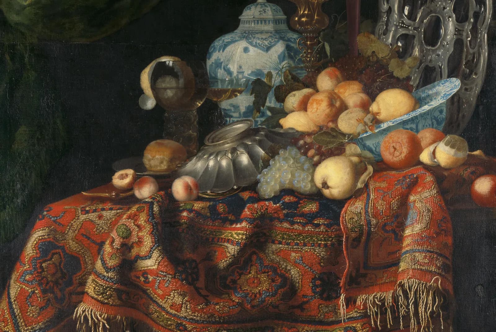 Stilleven met fruit, borden en schalen op een Turks tapijt